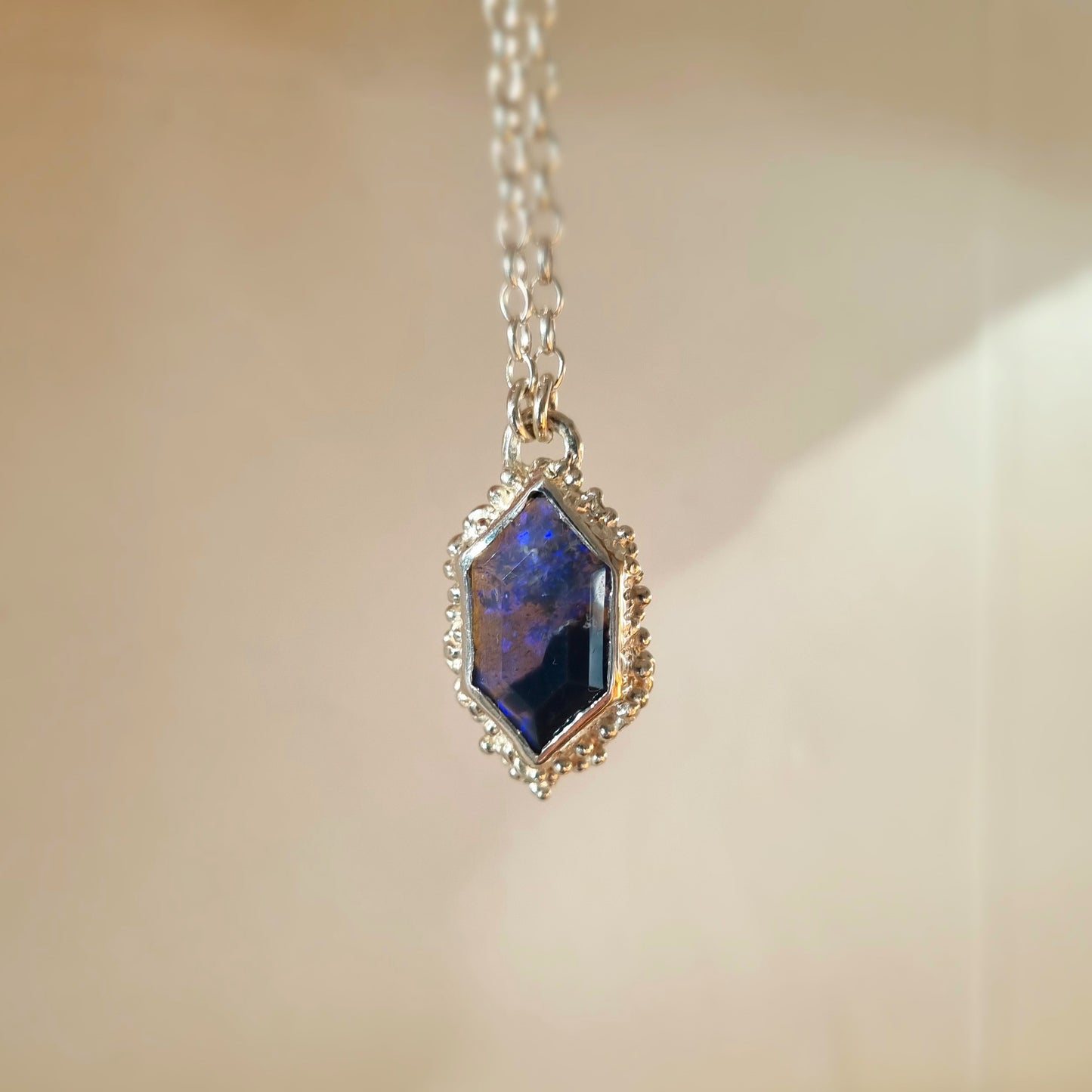 one-of-a-kind silver seafoam pendant with a black opal held by elizabeth french jewellery
