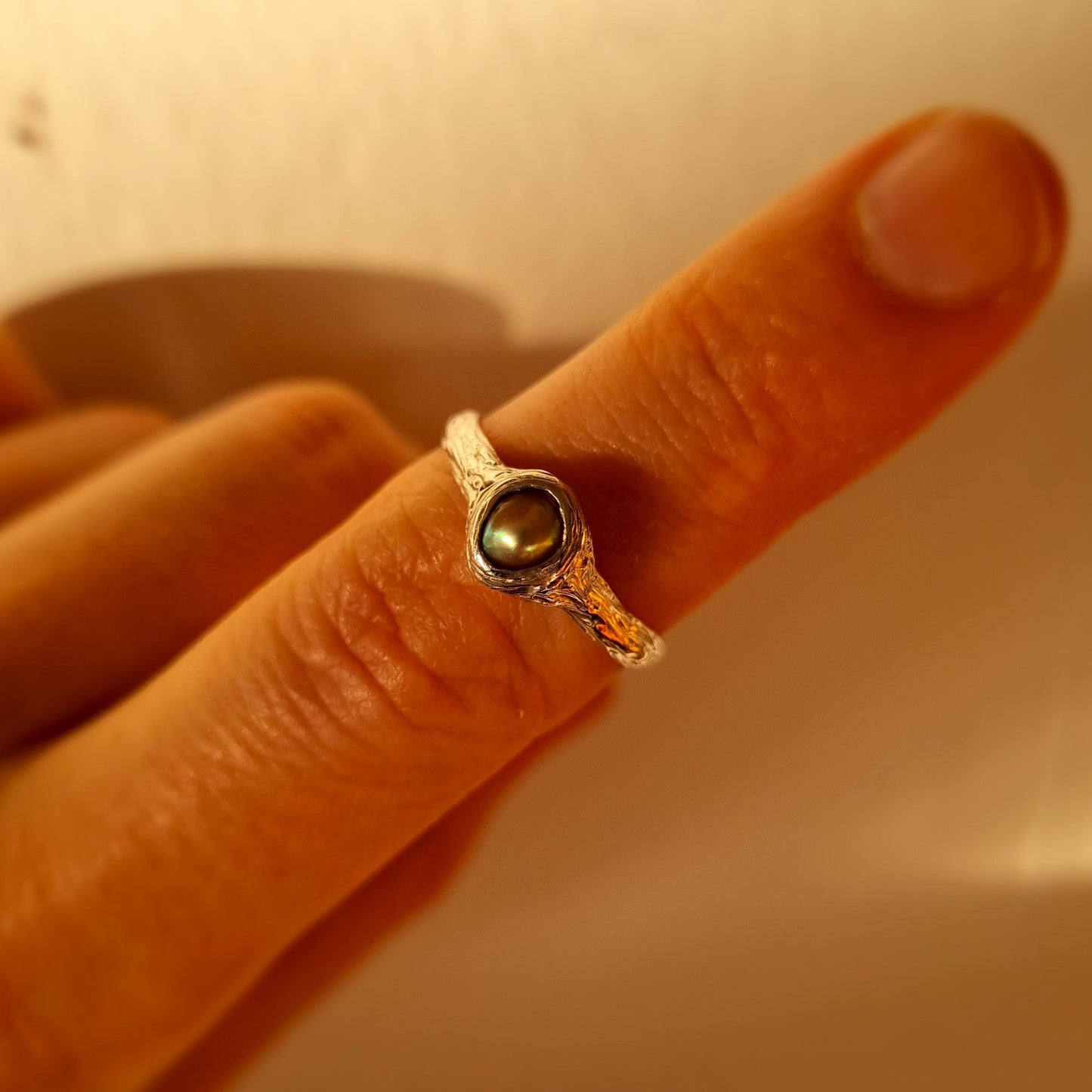 Silver ring with paua pearl on finger. Elizabeth French Jewellery